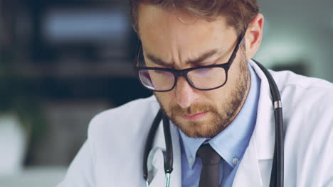médico serio, centrado y pensativo que escribe