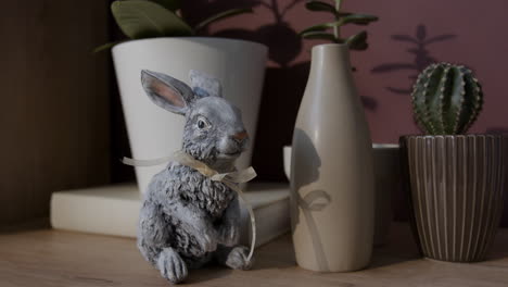 easter rabbit decor with plants and vases on a wooden shelf