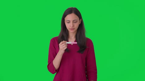 happy indian woman checking pregnancy test green screen