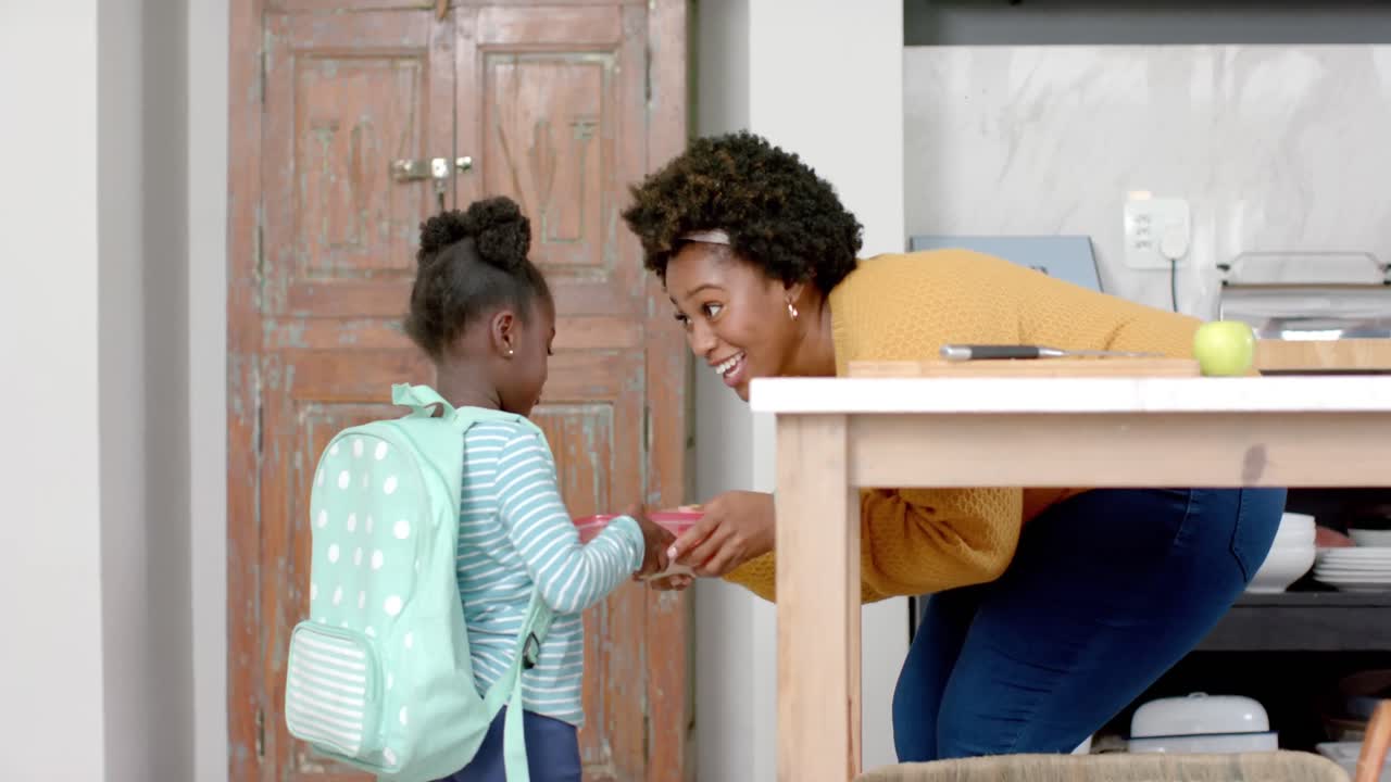 African american mother sending daughter to school at home, slow motion