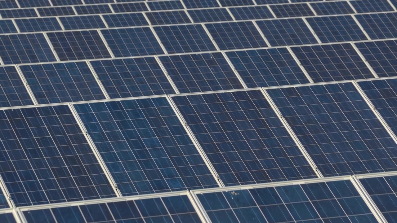 Vista aerea con drone di superfici di pannelli solari in dettaglio ravvicinato che mostrano i modelli a griglia delle celle fotovoltaiche in piena luce diurna, Moravia, Repubblica Ceca.