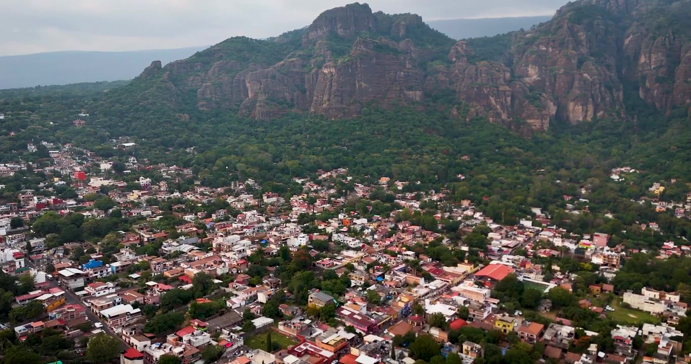 Ripresa aerea panoramica al tramonto della magica città di Tepoztlán, circondata da montagne, vicino a Città del Messico.