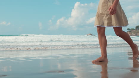 unknown girl walking along seaside. unrecognizable lady relaxing at beach.