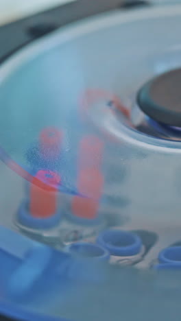 modern centrifuge machine is working in the medical laboratory. test tubes with blood inside the centrifuge. close-up. top view. vertical video