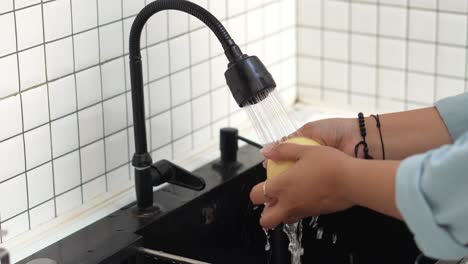 mujer lavando peras frescas maduras en la cocina se prepara para hacer batido