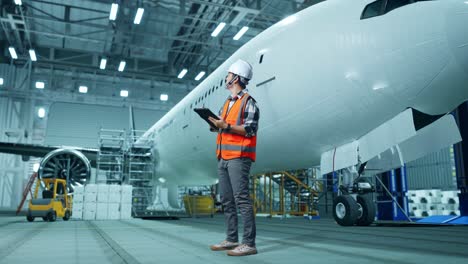 técnico de aviones inspeccionando en el hangar