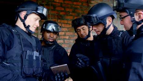 side view of mixed-race military soldiers with rifles planing and discussing their plan at base 4k