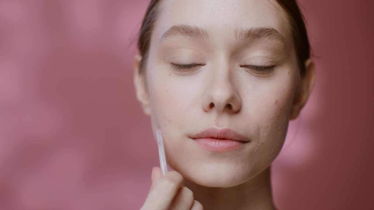mujer recibiendo masaje facial de gua sha