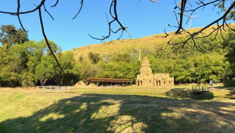 straw house amidst trees and hills in thailand