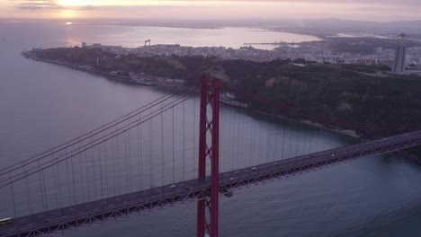 Side-panning-shot-of-The-25-de-Abril-Suspension-Bridge-over-Tagus-river-in-Lisbon,-aerial