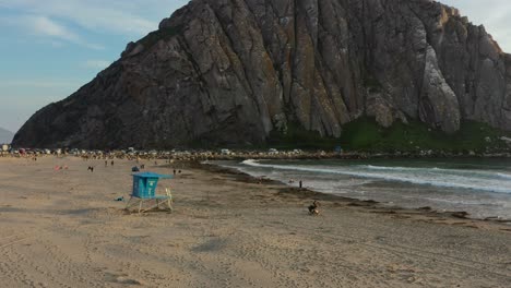 amplia vista aérea de un puesto de salvavidas en morro bay rock beach en california, ee.uu. mientras los turistas disfrutan de la playa durante una tarde de verano