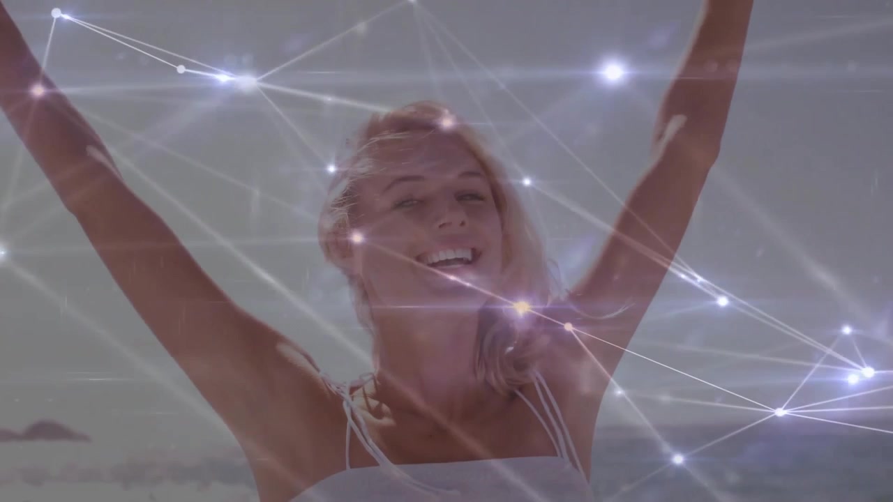 Mujer levantando los brazos y activando pulsos de red luminosos para una visualización tecnológica en la playa.