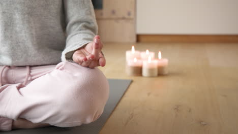 meditating at home, woman practicing yoga with candles on floor, copy space