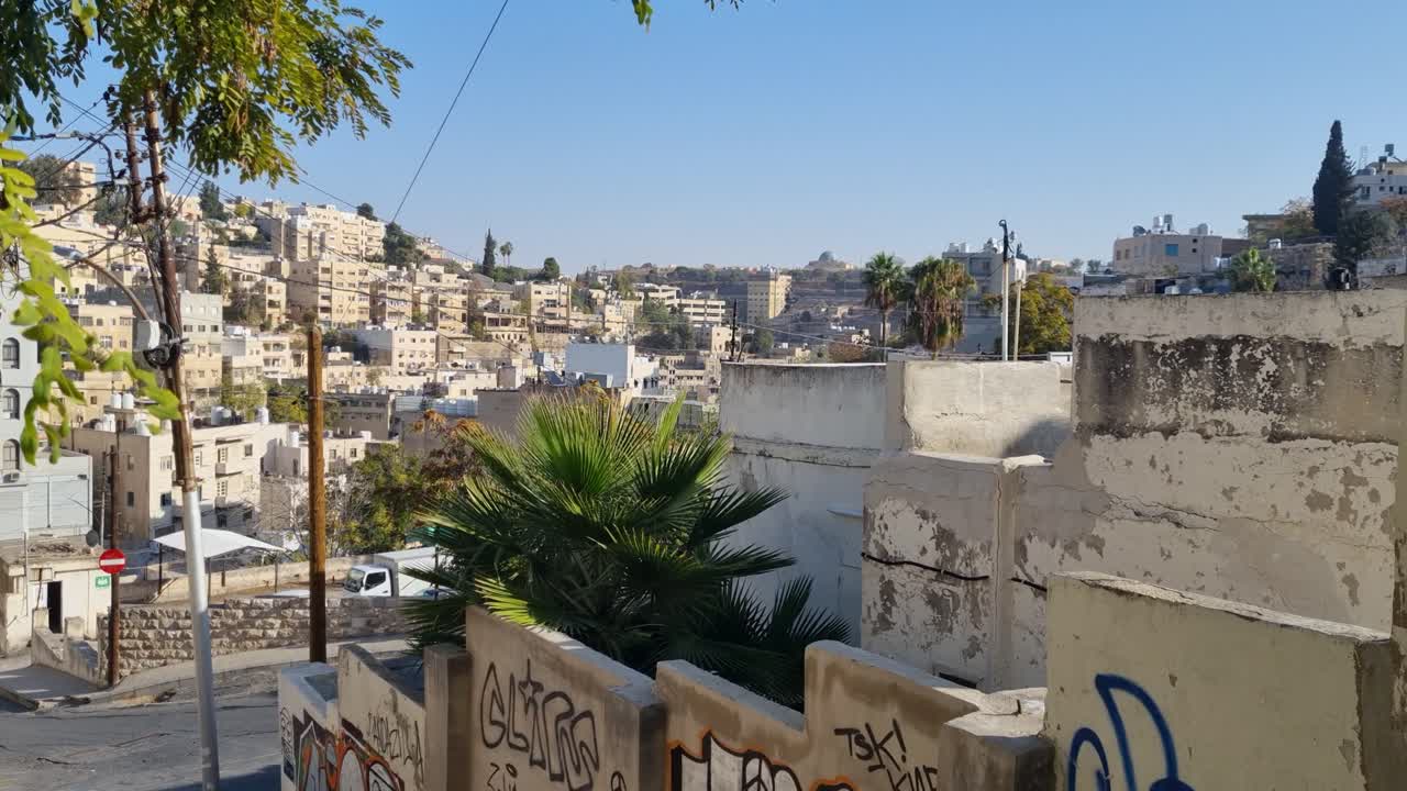 Ampia vista panoramica su un quartiere residenziale di Amman, in Giordania, catturata in una limpida mattina d'inverno, con edifici in pietra e la vita quotidiana nella vivace capitale mediorientale