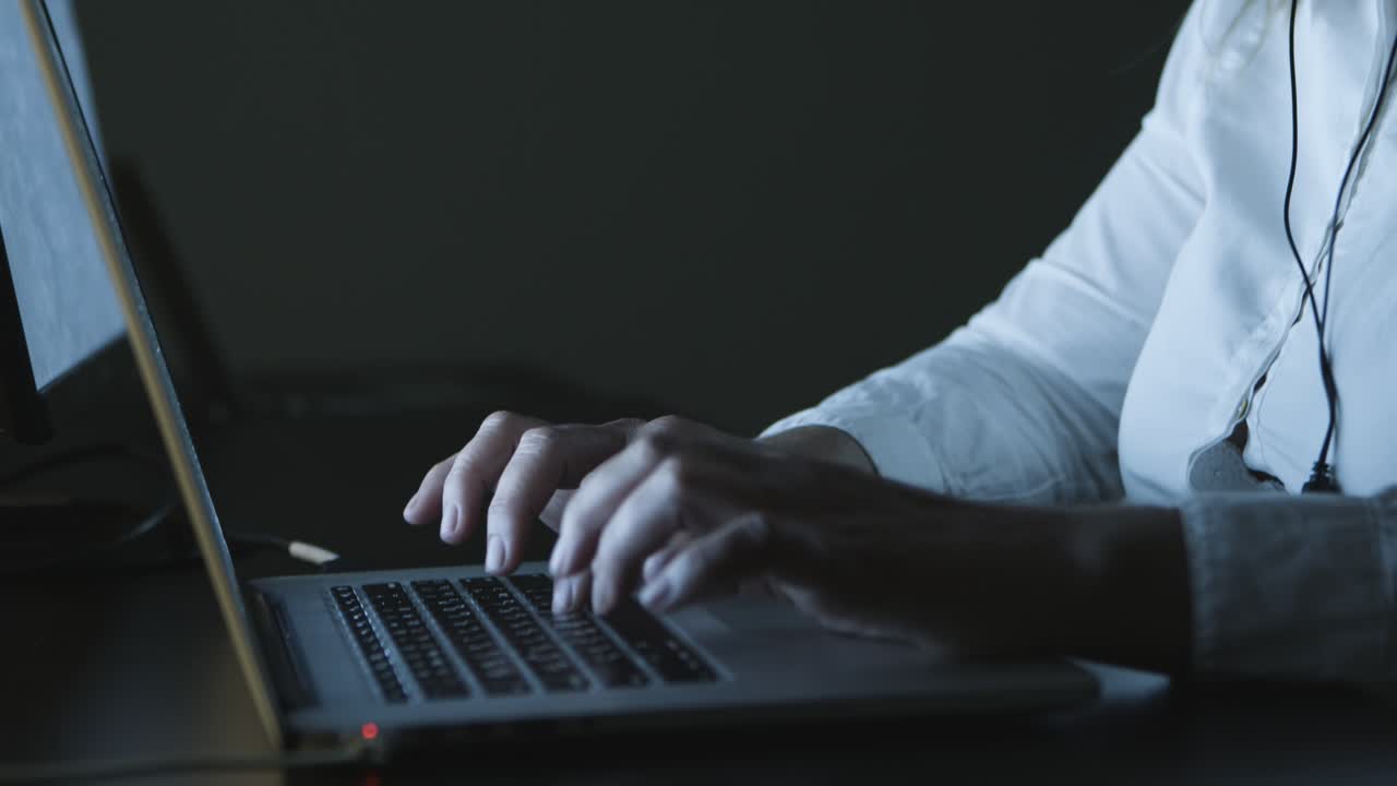 Serious businesswoman in headset using laptop
