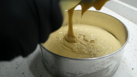 the chef is pouring ingredients into a container and blender for grinding purposes. these ingredients will be thoroughly blended and ready for the next steps.