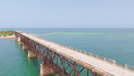 Aerial-shot-along-a-broken-bridge-over-the-ocean-in-Los-Angeles