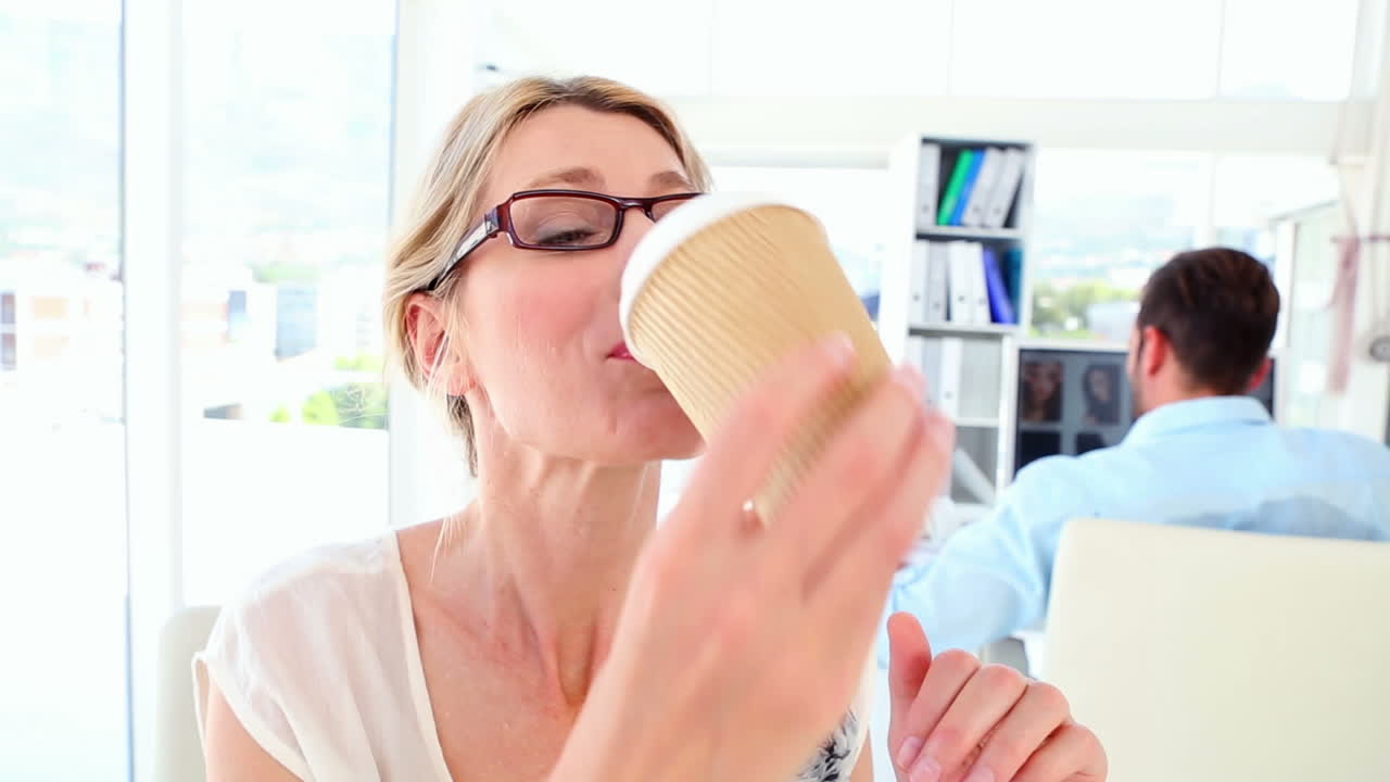 잠자는 사업가 여성이 커피를 마시고 엄지손가락을 들어 올립니다.