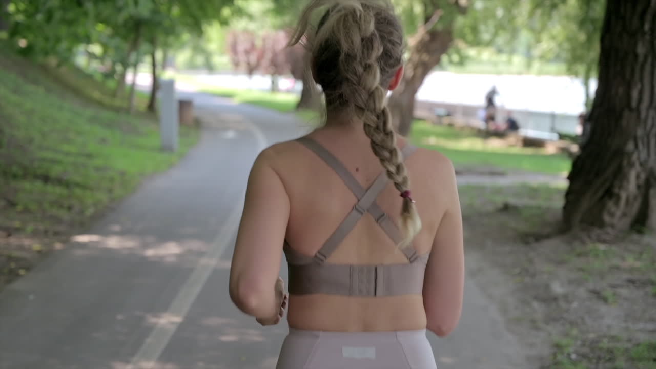 Woman in beige sportswear working out in the park