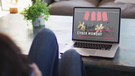 woman at table using laptop, online shopping on cyber monday, slow motion