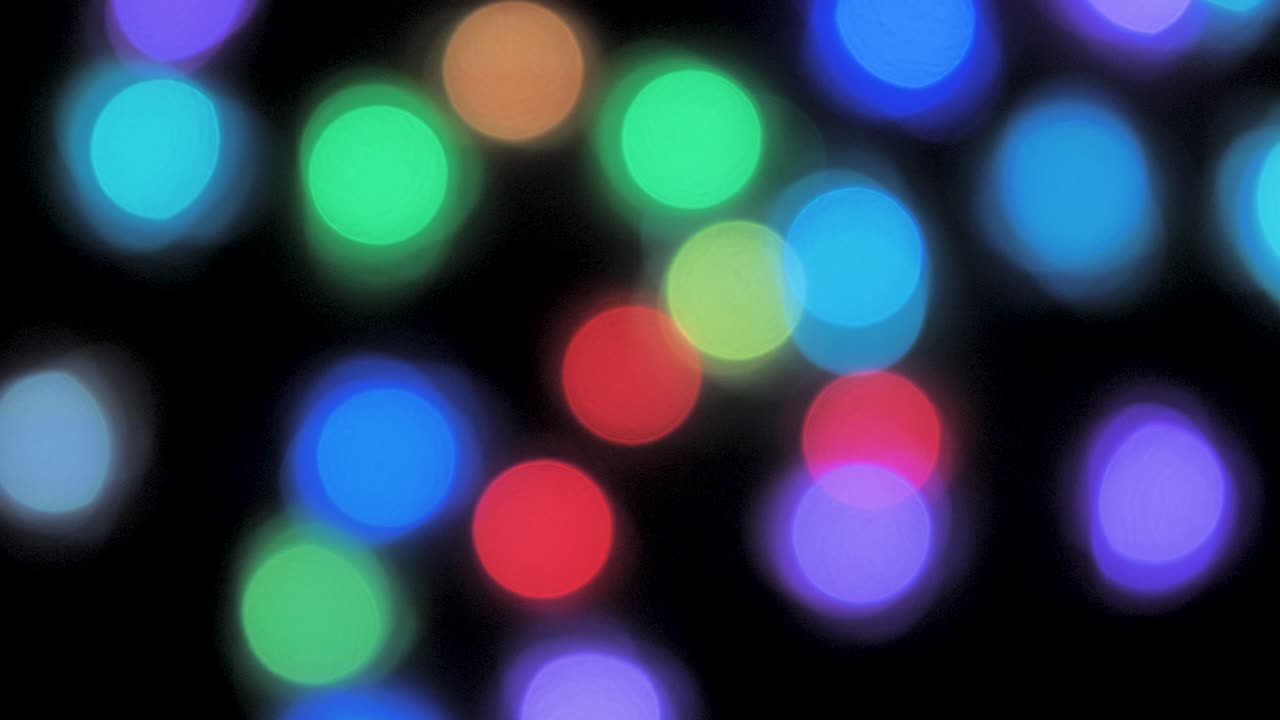 Colorful christmas lights bokeh moving on dark background