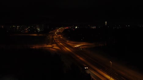 aerial: vehicle exits divided highway on winter night near helsinki
