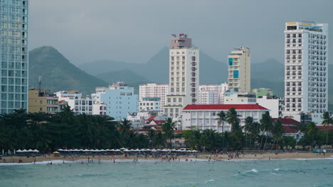 Vista-Panorámica-De-La-Ciudad-De-Nha-Trang-Y-La-Playa-De-Hon-Chong,-Hoteles-Y-Complejos-Turísticos-Contra-Las-Imponentes-Montañas-Al-Atardecer,-Vietnam