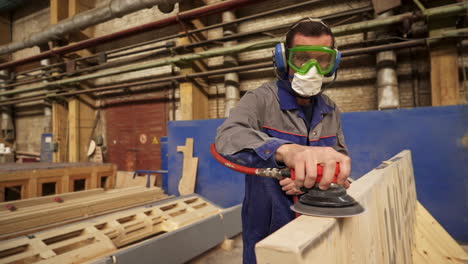 worker sanding wood in a factory