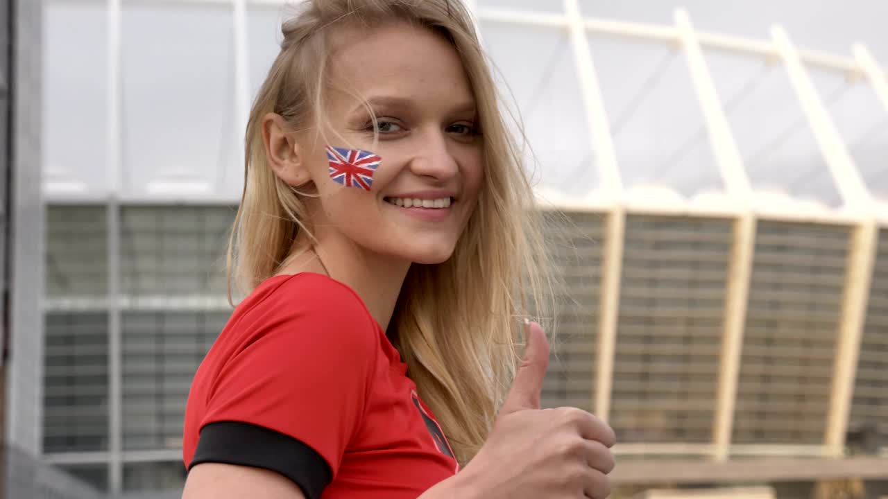 영국 축구 팬의 금발 소녀, 미소, 표지판과 같은 표지판, 챔피언십 컨셉, 배경의 경기장 50 fps