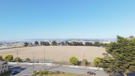 aerial view of bernal heights shows its circular summit and panoramic backdrop of city towers and bay waters