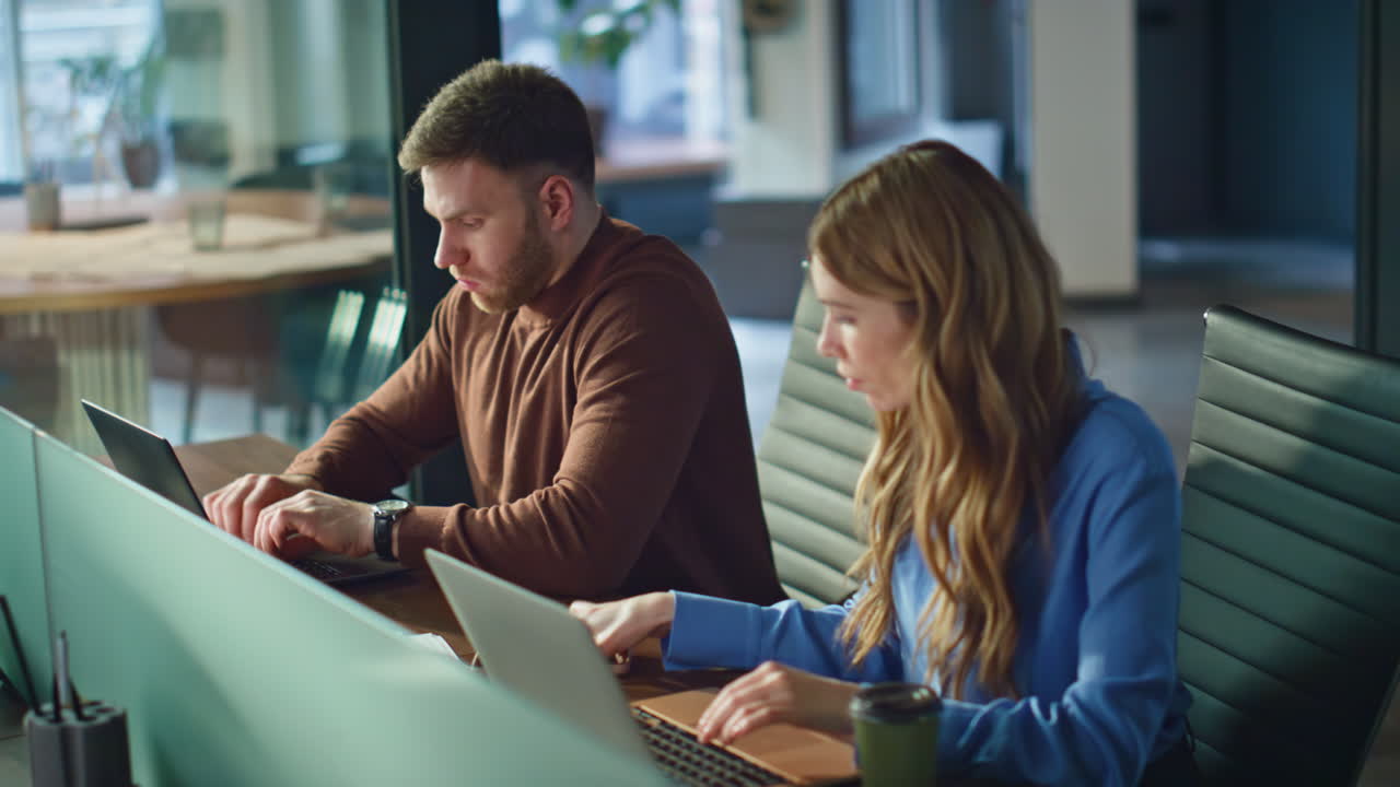 Fatigued colleagues looking laptops working together at business project closeup