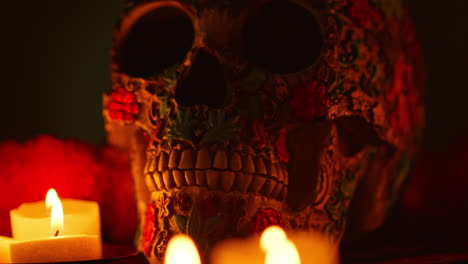 close up on still life of decorated skulls lit by candles celebrating mexican holiday of dia de muertos or day of the dead 2