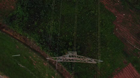 Top down aerial of long power cables running through a transmission tower in rural Nigeria, Africa