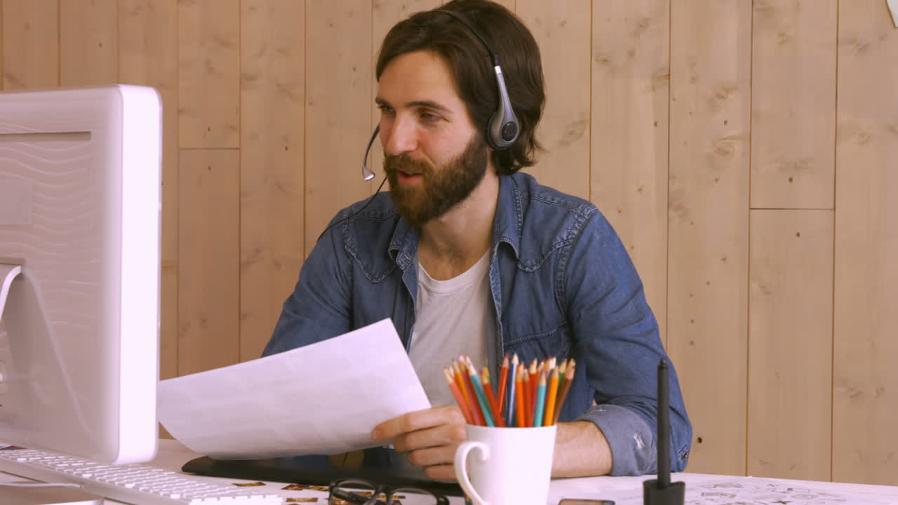 Hipster worker using video chat at desk