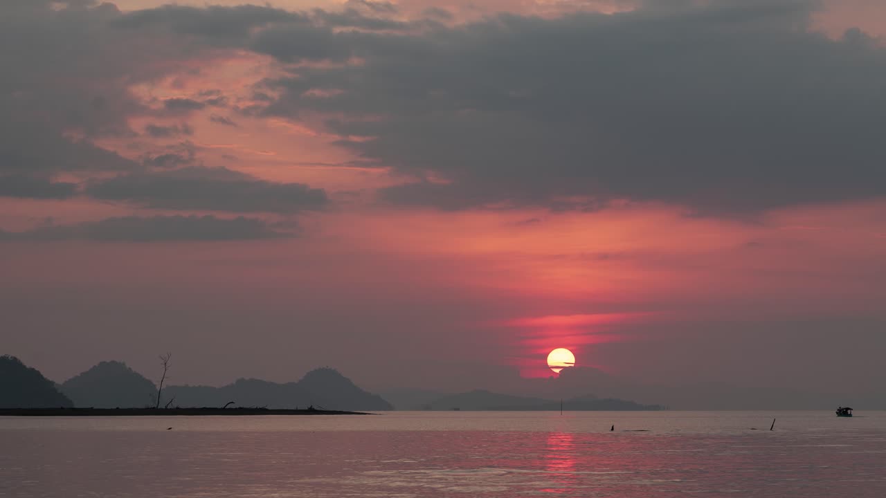 Vibrant Sunset Over a Lake with Mountain Silhouettes