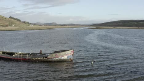 an aerial view of an old shipwreck on the keillmore peninsula on a sunny day in argyll and bute, scotland