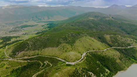 sinuate road going round the hill covered with pine trees. scenic picture of beautiful mountains of colorado, usa. aerial view.