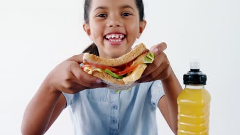 chica linda sosteniendo un sándwich contra un fondo blanco
