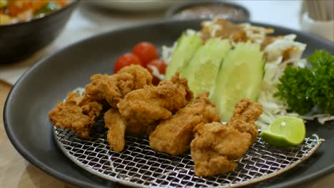 접시에서 집어드는 젓가락을 사용하면서 치킨 가라아게 일식에 pov