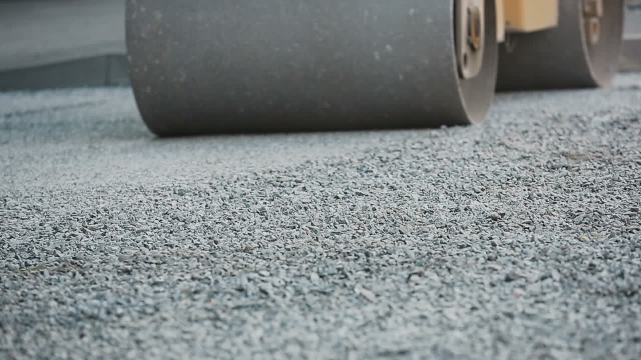 Road roller laying gravel during road construction