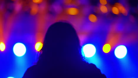 happy people are watching an amazing musical concert. multicolored light at a music festival.