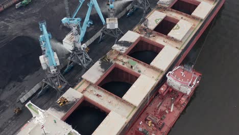 aerial drone close up view of coal transshipment to cargo ship