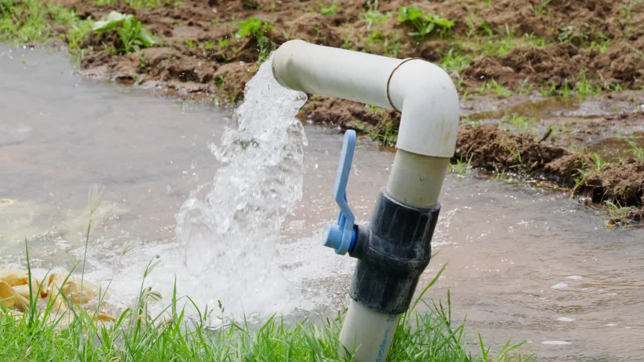 bore water coming from pipe to use in crop field lands, day time, stable shot, 4k.