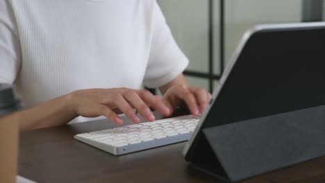 woman using digital tablet with working, type keyboard on office desk.
