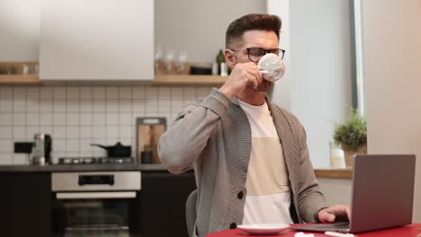 man drinking coffee and working from home