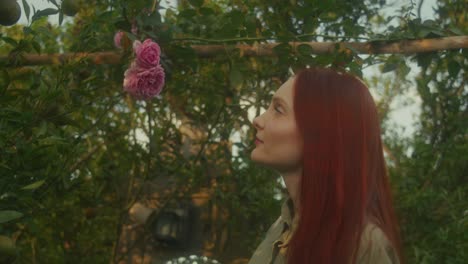woman smelling a rose in a garden