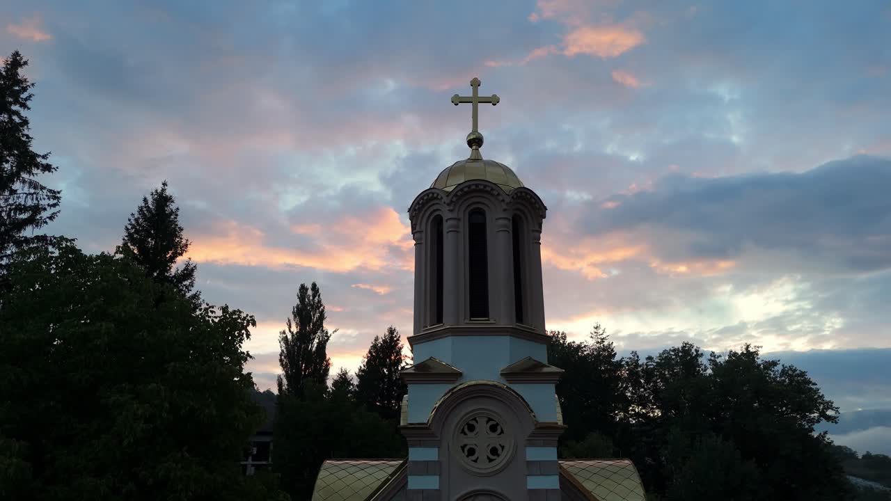 Aerial drone view of the Orthodox Church in Jajce, Bosnia and Herzegovina, surrounded by historic stone houses and green hills in the heart of the Balkans