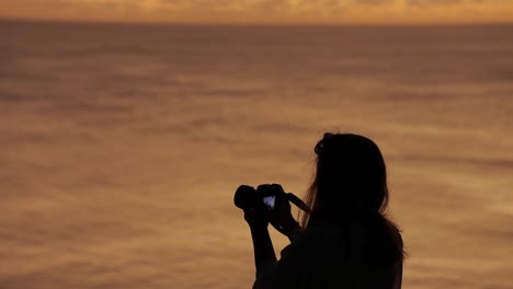 Handheld-Aufnahmen-Der-Silhouette-Einer-Frau,-Die-Bilder-Bei-Sonnenuntergang-Aufnimmt