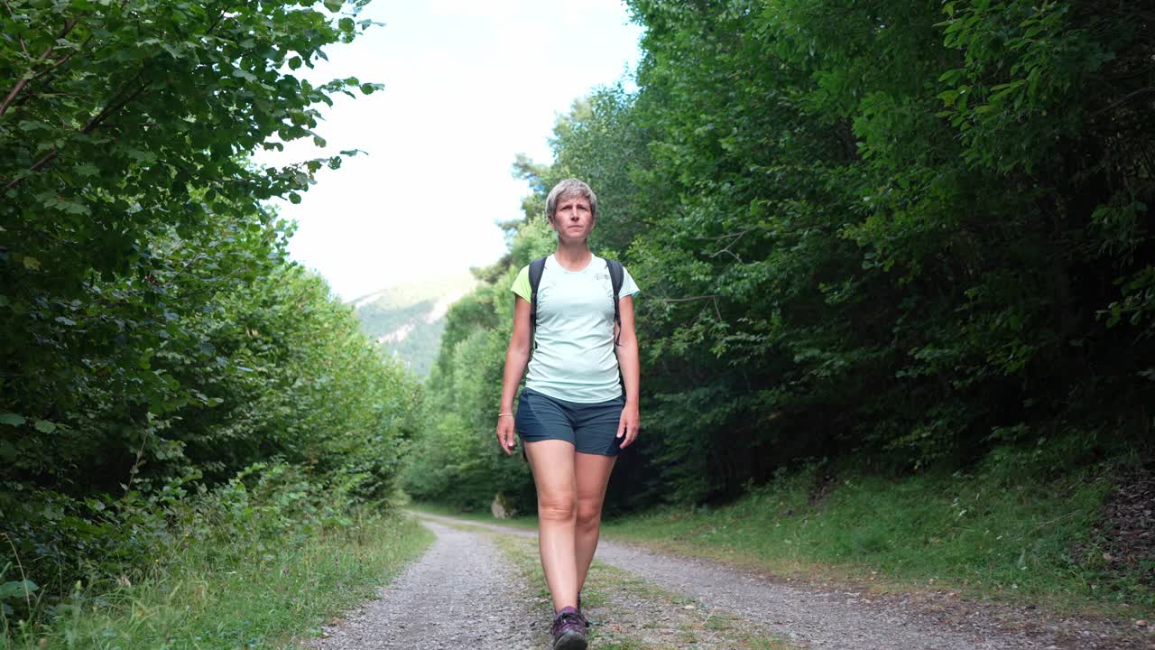 Eine Frau wandert auf einem Waldweg