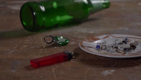 맥주병 유리와 재떨이 로우 앵글 슬라이더 샷이 있는 테이블